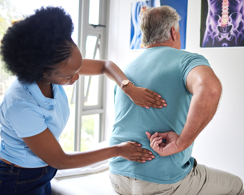 Physical therapist assisting patient with back pain