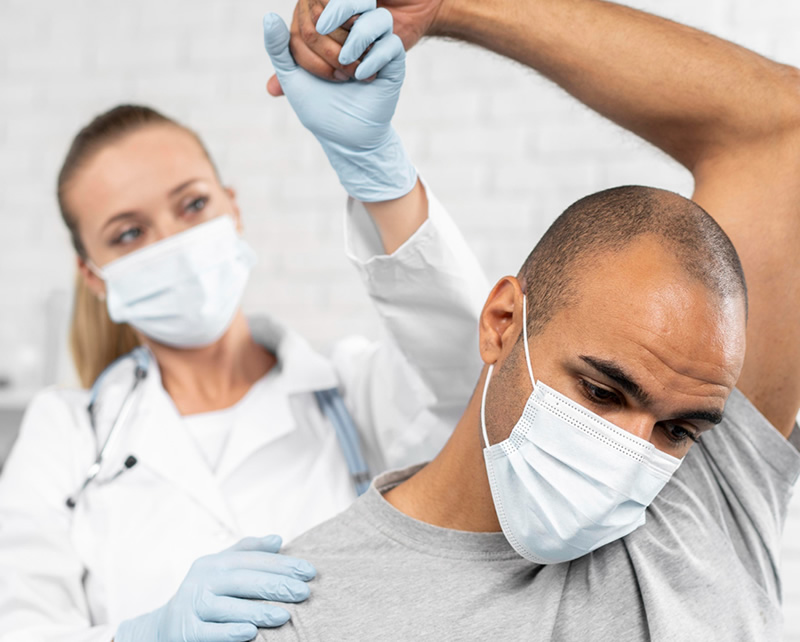 Physical therapist helping patient with shoulder pain treatment and rehabilitation